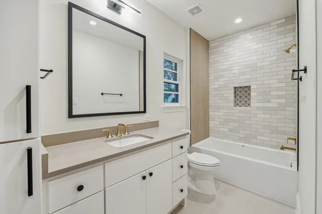a bathroom with a granite countertop sink a toilet and a bathtub