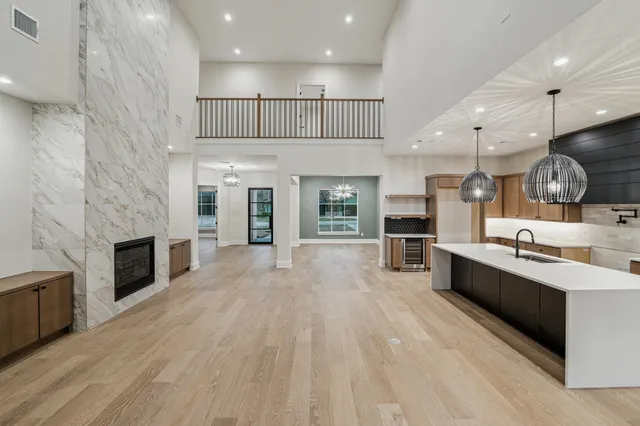 a large kitchen with stainless steel appliances kitchen island granite countertop a large counter top and a stove top oven