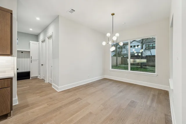 a view of a livingroom with wooden floor a ceiling fan and window