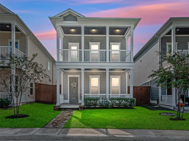 a front view of a house with a yard and potted plants