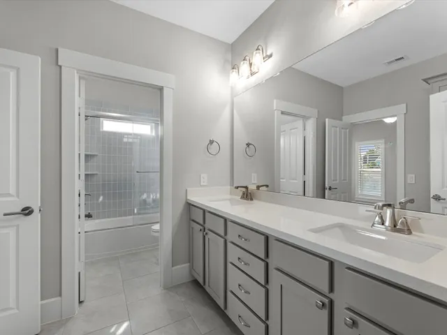 a bathroom with double sink and a mirror