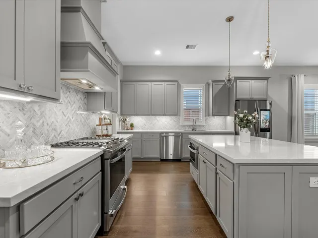 a kitchen with stainless steel appliances a sink stove and cabinets
