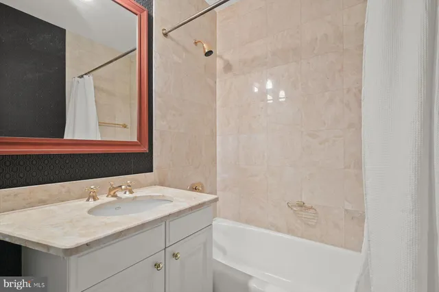 a bathroom with a granite countertop sink and a bathtub