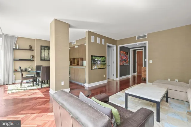 a living room with furniture a flat screen tv and a table