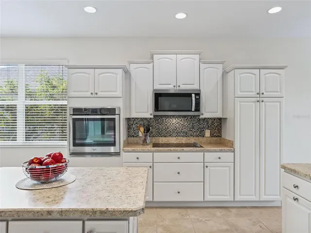 a kitchen with white cabinets and appliances