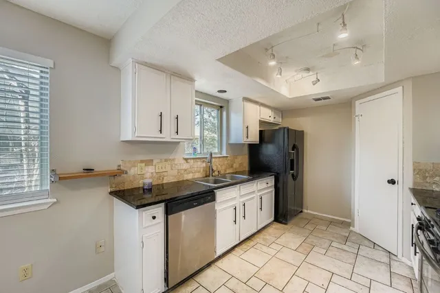 a kitchen with stainless steel appliances granite countertop a sink stove and cabinets