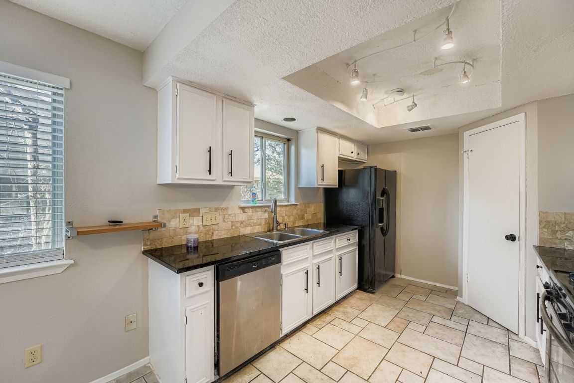 1415 Lance Way Austin, TX 78758 - Photo 11 of 29 a kitchen with stainless steel appliances granite countertop a sink stove and cabinets