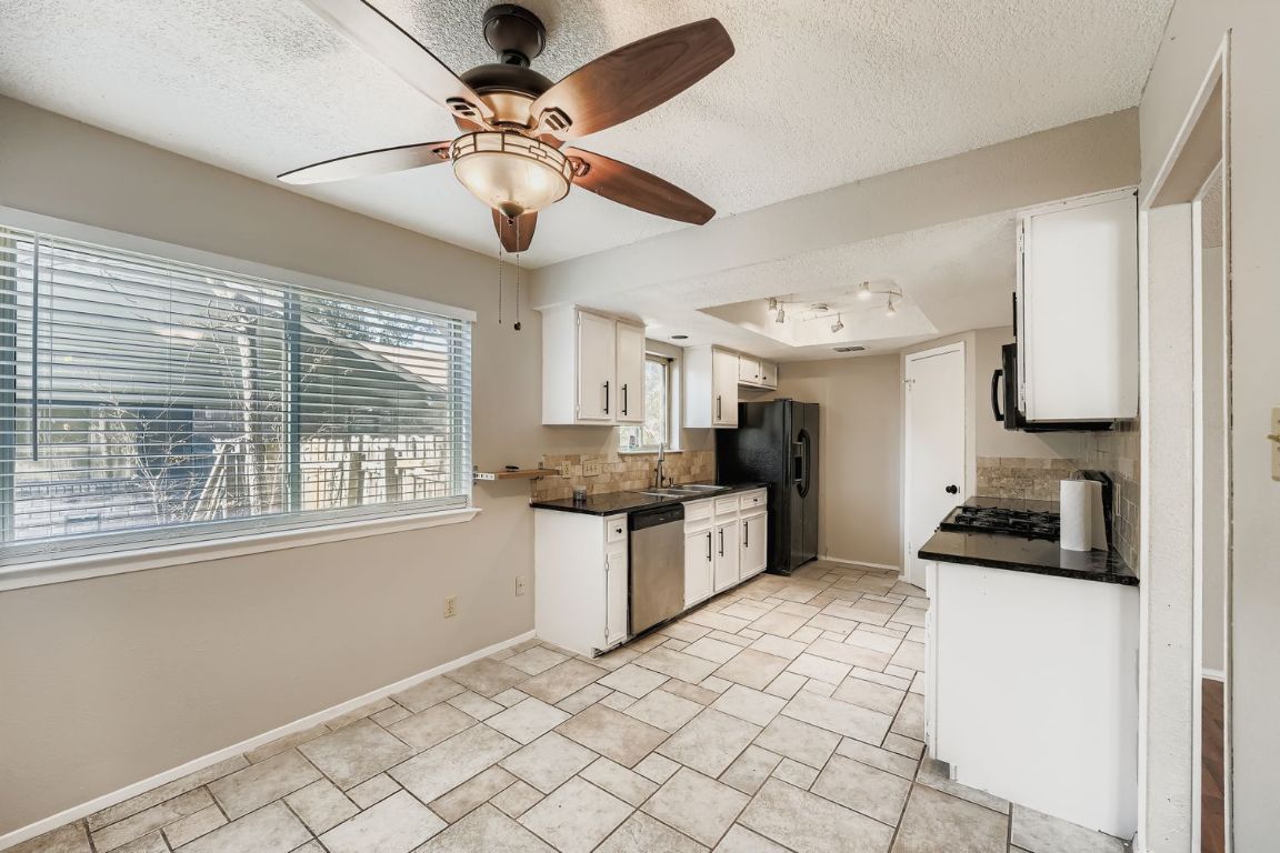 1415 Lance Way Austin, TX 78758 - Photo 15 of 29 a kitchen with a stove a sink and cabinets