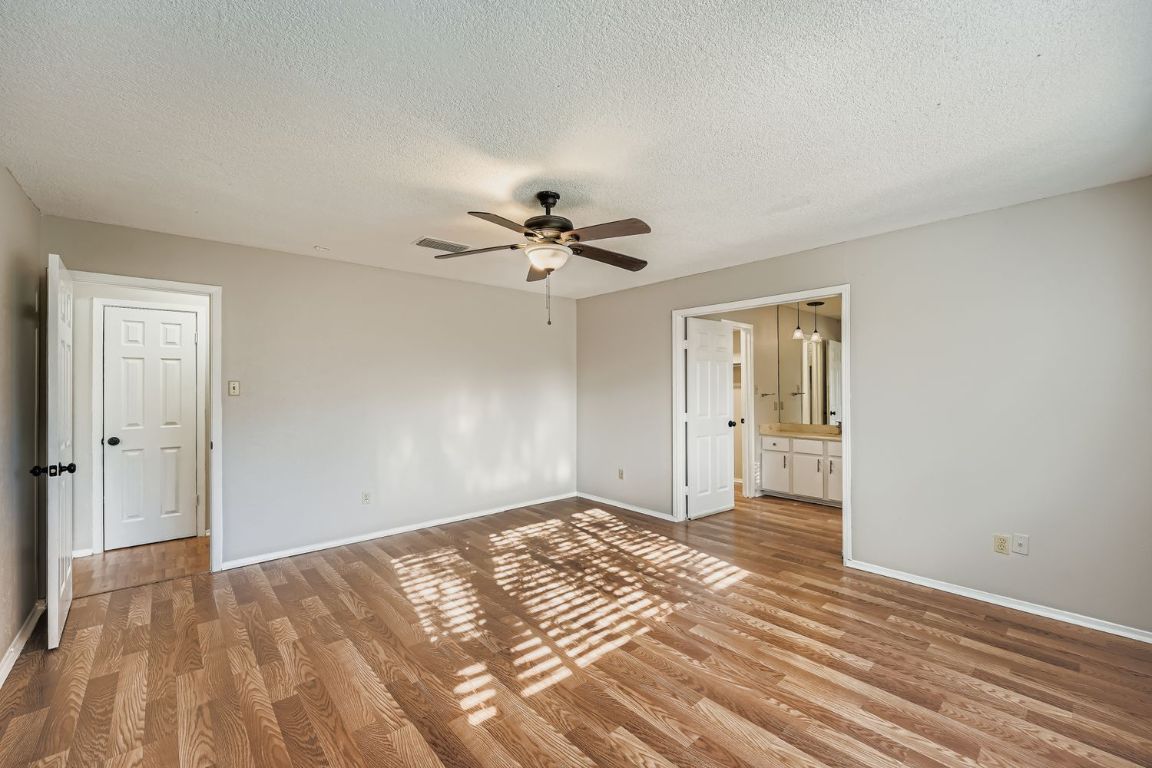 1415 Lance Way Austin, TX 78758 - Photo 18 of 29 a view of empty room with wooden floor and ceiling fan
