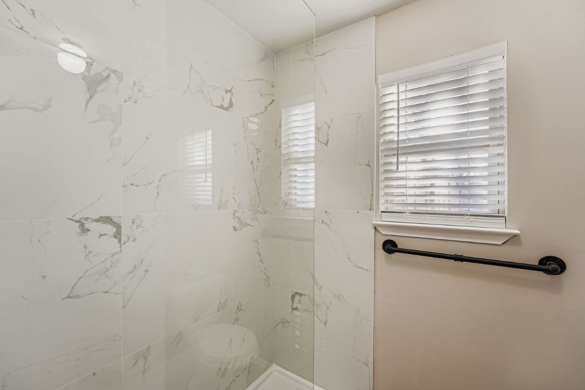 1415 Lance Way Austin, TX 78758 - Photo 20 of 29 a bathroom with a window and a shower