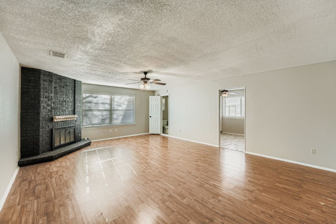 1415 Lance Way Austin, TX 78758 - Photo 5 of 29 a view of an empty room with wooden floor and a window