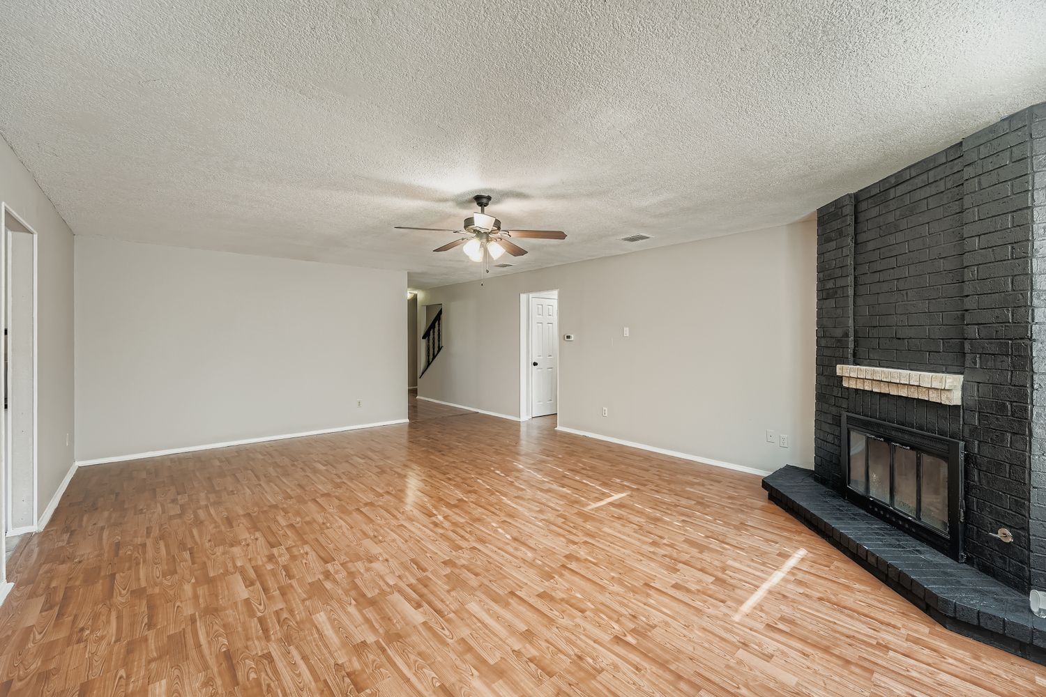 1415 Lance Way Austin, TX 78758 - Photo 7 of 29 a view of an empty room with wooden floor fireplace and a window
