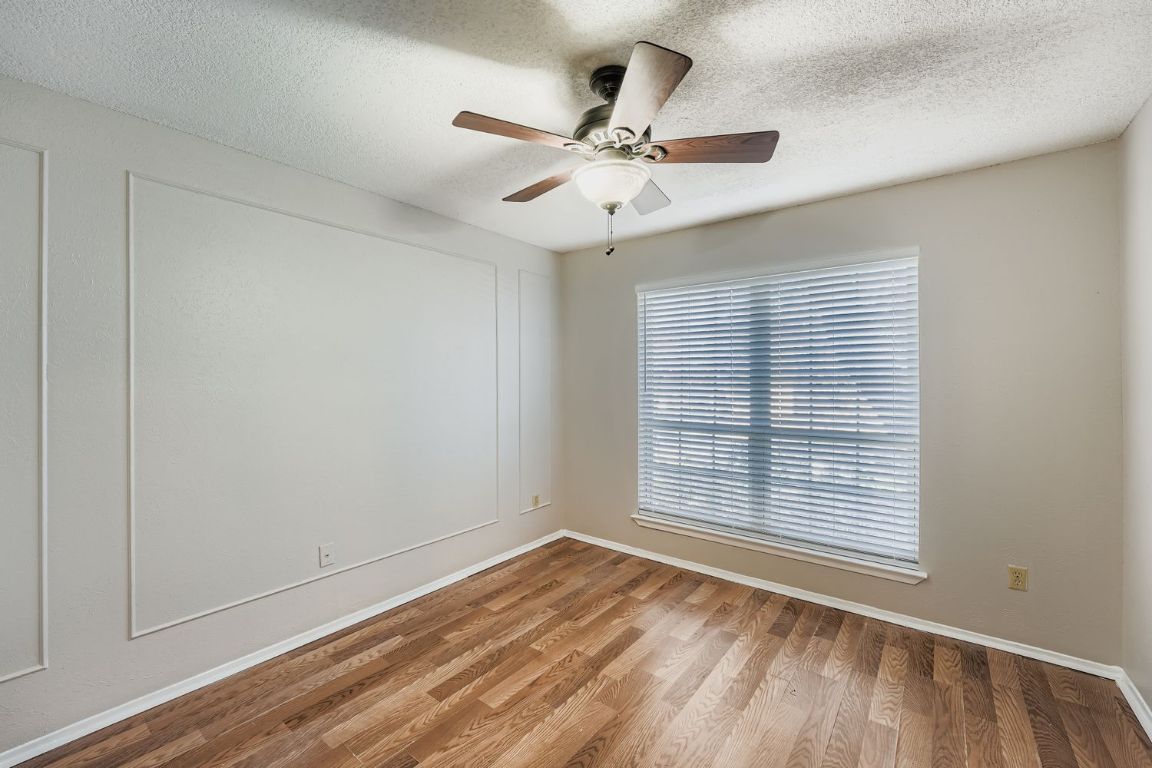 1415 Lance Way Austin, TX 78758 - Photo 9 of 29 a view of an empty room with wooden floor and a window