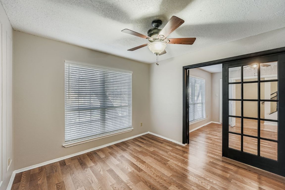 1415 Lance Way Austin, TX 78758 - Photo 10 of 29 a view of an empty room with wooden floor and a window