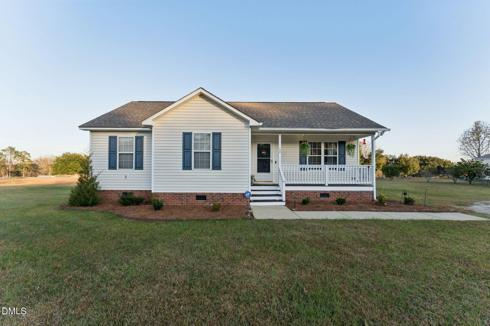a front view of a house with a yard and trees