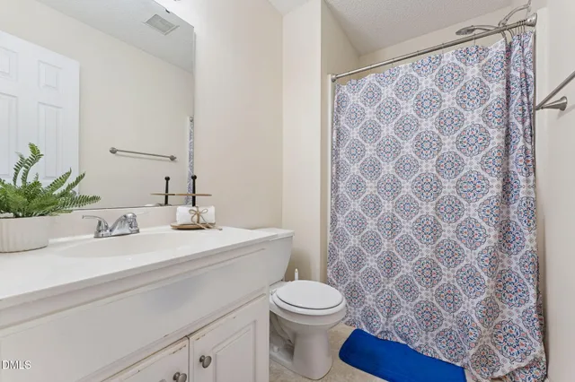 a bathroom with a granite countertop sink a toilet and a mirror