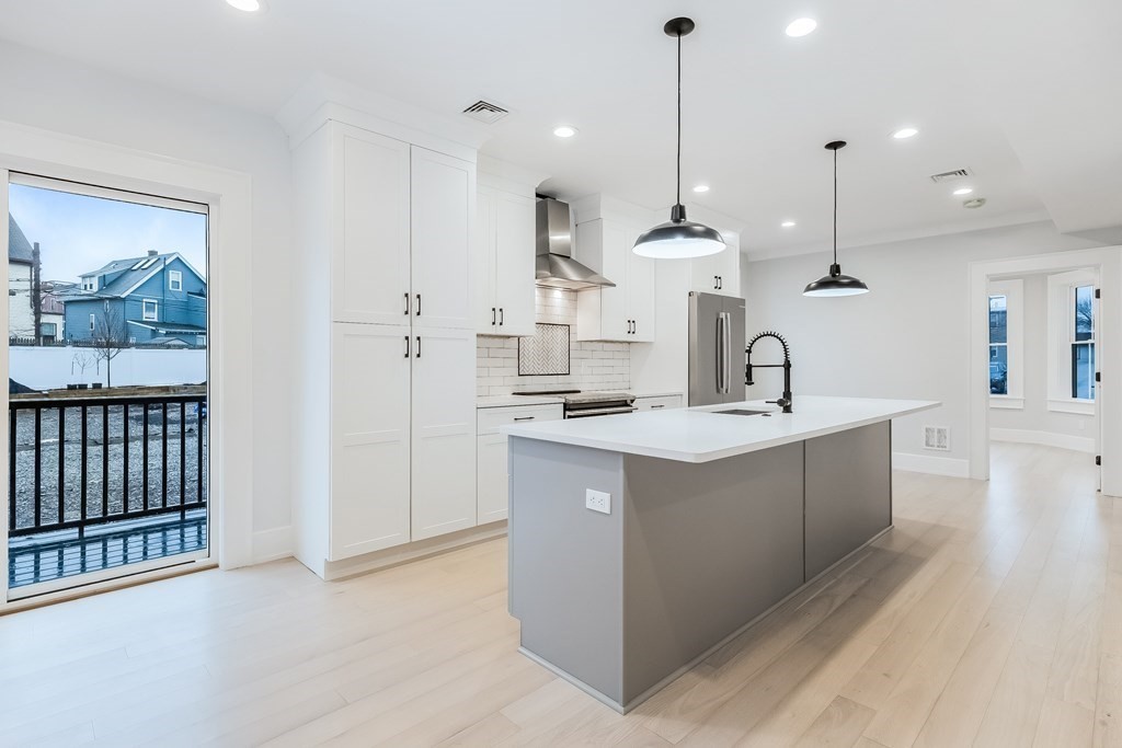13 McKone Street, Unit 1 Boston, MA 02122 - Photo 1 of 36 a kitchen with kitchen island a sink stainless steel appliances and cabinets