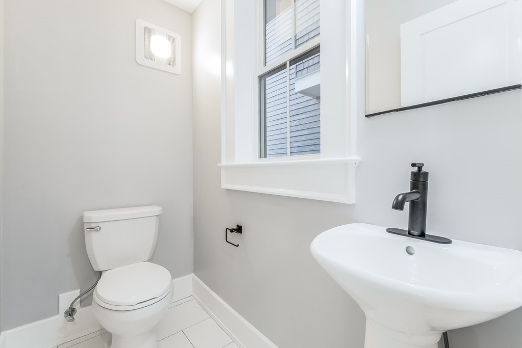 13 McKone Street, Unit 1 Boston, MA 02122 - Photo 14 of 36 a bathroom with a toilet sink and mirror