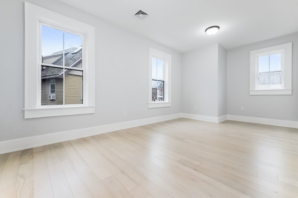 13 McKone Street, Unit 1 Boston, MA 02122 - Photo 19 of 36 a view of an empty room with a window and wooden floor