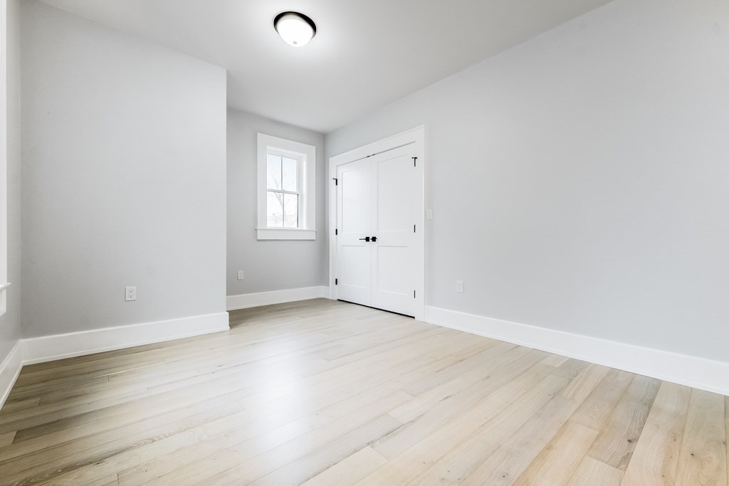 13 McKone Street, Unit 1 Boston, MA 02122 - Photo 20 of 36 a view of an empty room with wooden floor and a window
