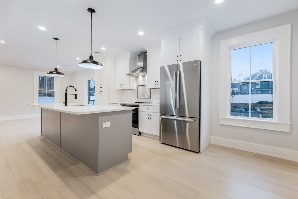 13 McKone Street, Unit 1 Boston, MA 02122 - Photo 2 of 36 a kitchen with stainless steel appliances granite countertop a sink a refrigerator and a window
