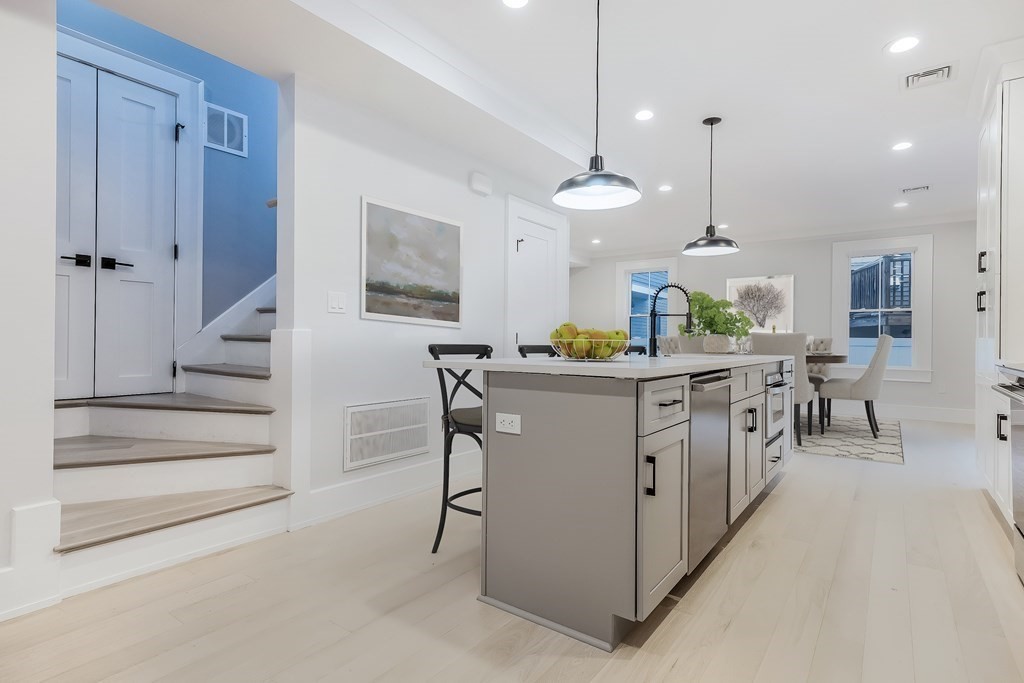 13 McKone Street, Unit 1 Boston, MA 02122 - Photo 3 of 36 a kitchen with stainless steel appliances kitchen island granite countertop a table chairs and a refrigerator