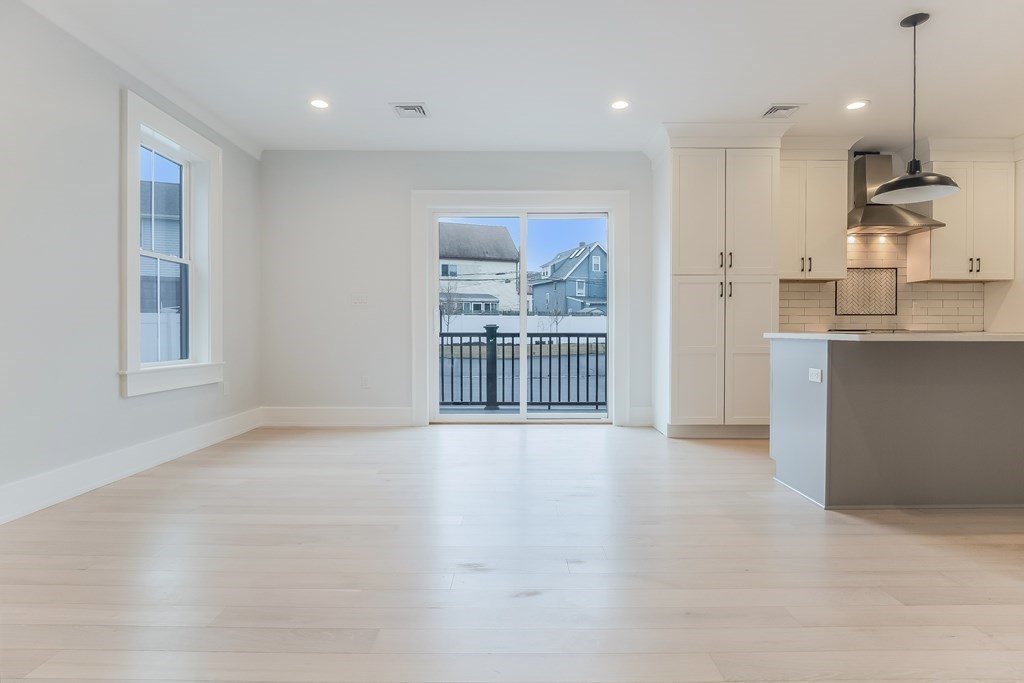 13 McKone Street, Unit 1 Boston, MA 02122 - Photo 9 of 36 an empty room with windows and kitchen view