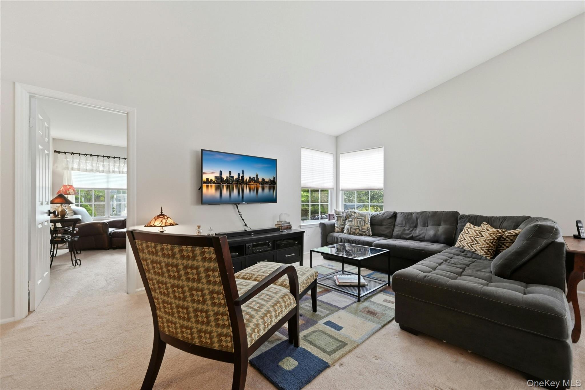 9 Baldwin Court, Unit 9 Ridge, NY 11961 - Photo 15 of 27 a living room with furniture and a flat screen tv