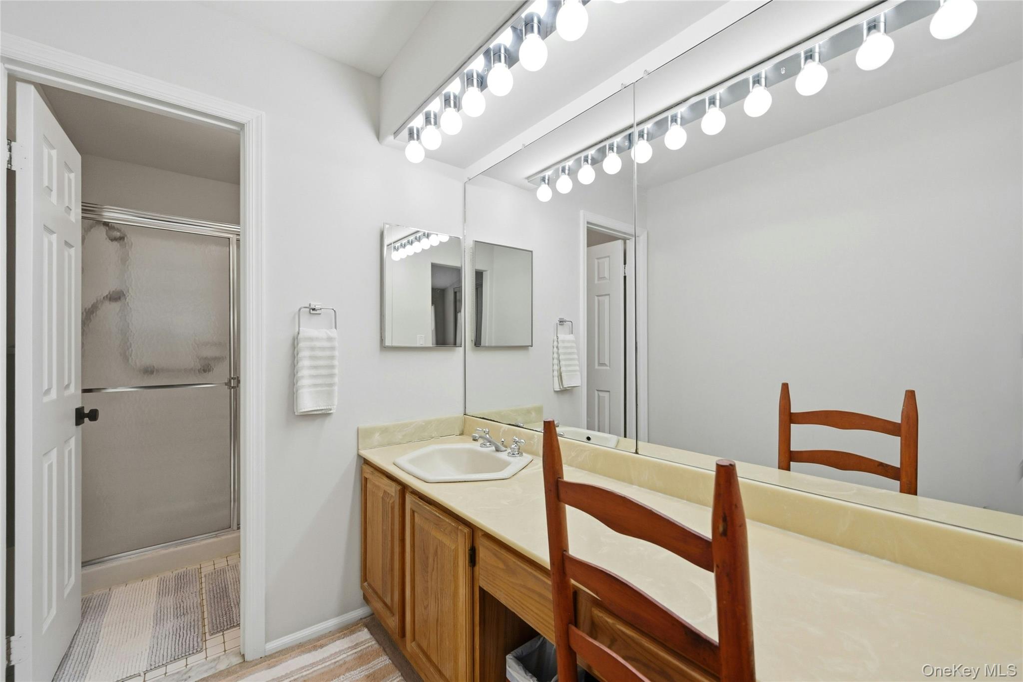 9 Baldwin Court, Unit 9 Ridge, NY 11961 - Photo 21 of 27 a bathroom with a sink a large mirror and shower