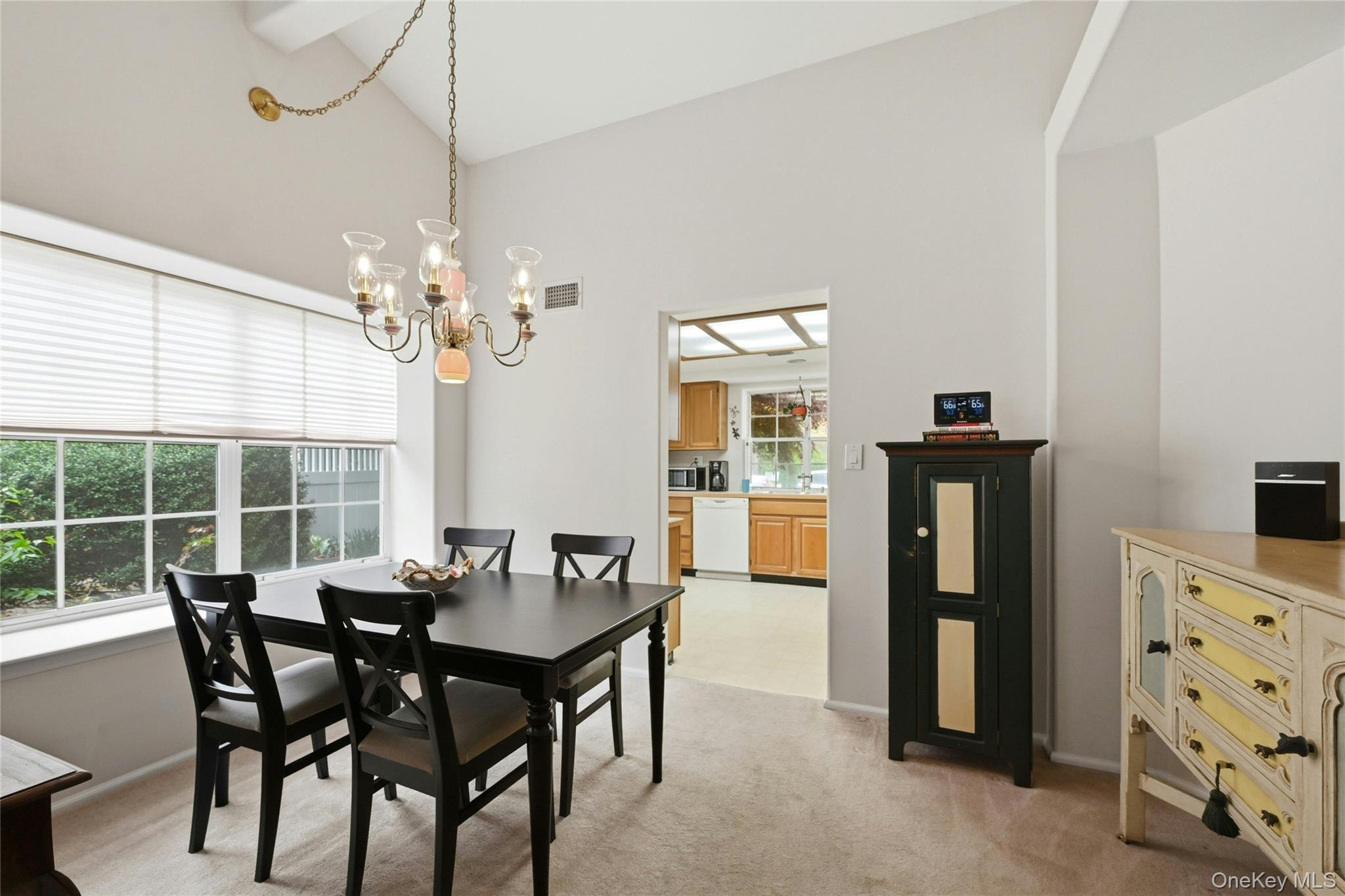 9 Baldwin Court, Unit 9 Ridge, NY 11961 - Photo 8 of 27 a view of a dining room with furniture and chandelier