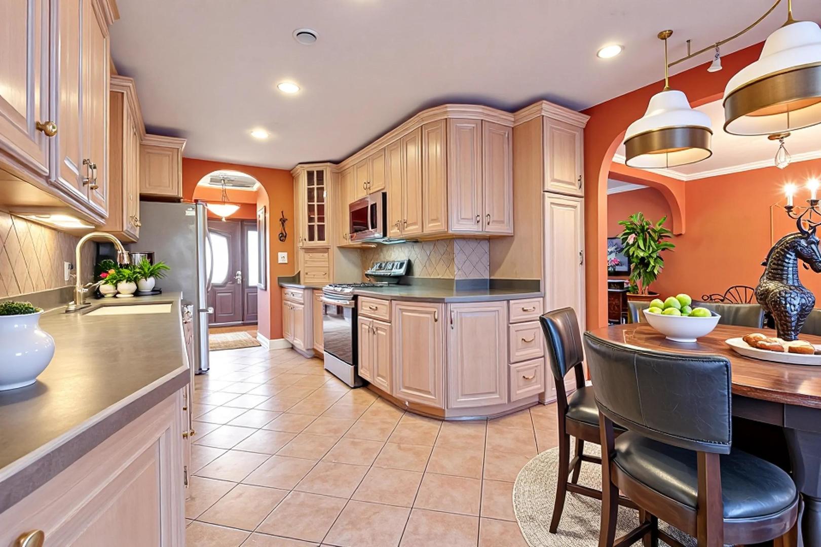2016 Seneca Lane Mount Prospect, IL 60056 - Photo 3 of 33 a kitchen with stainless steel appliances granite countertop a sink a stove a microwave a dining table and chairs