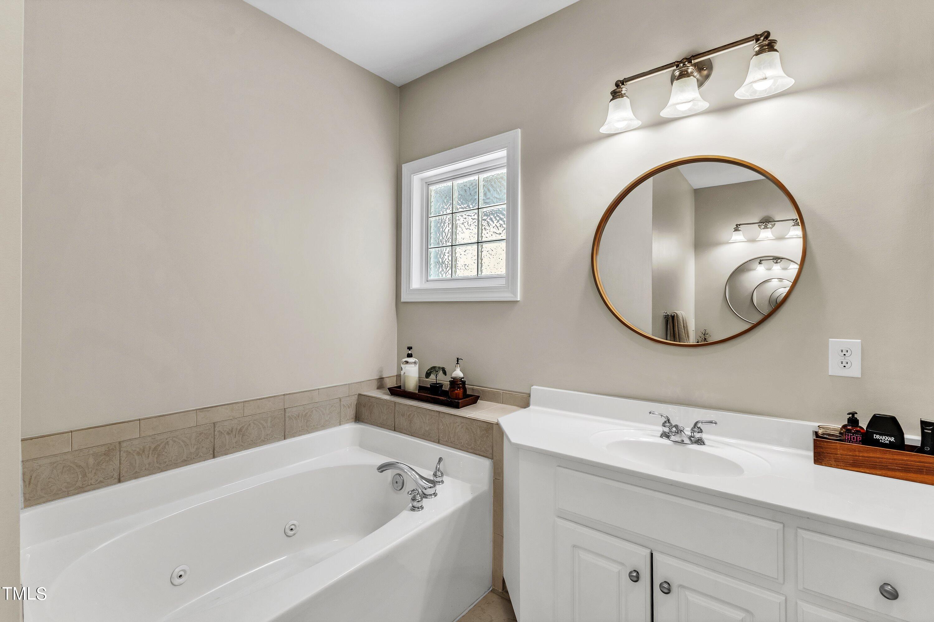 6323 Cedar Waters Drive Raleigh, NC 27607 - Photo 37 of 84 a bathroom with a bathtub sink and a mirror