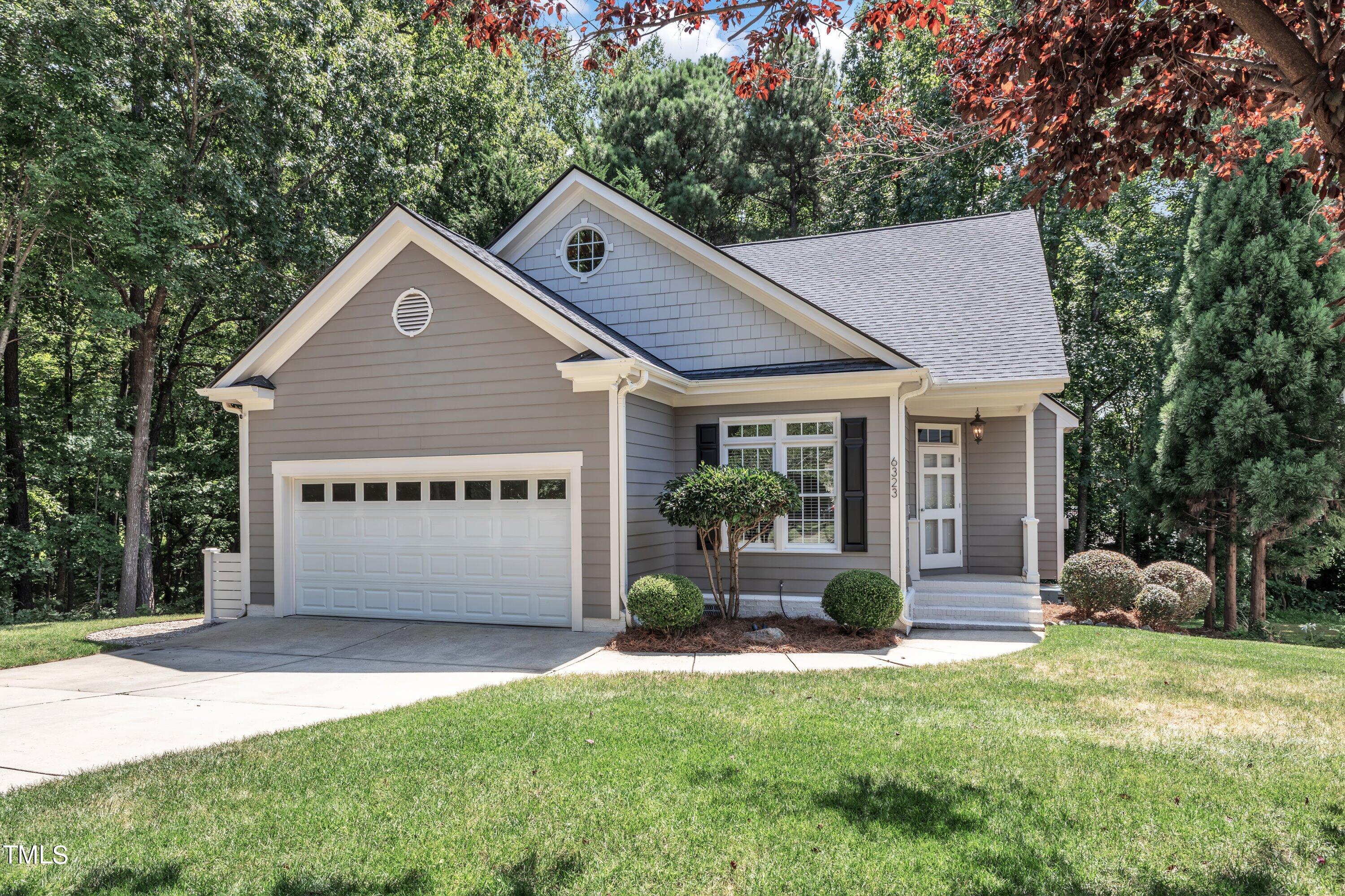 6323 Cedar Waters Drive Raleigh, NC 27607 - Photo 4 of 84 a front view of a house with a garden and plants