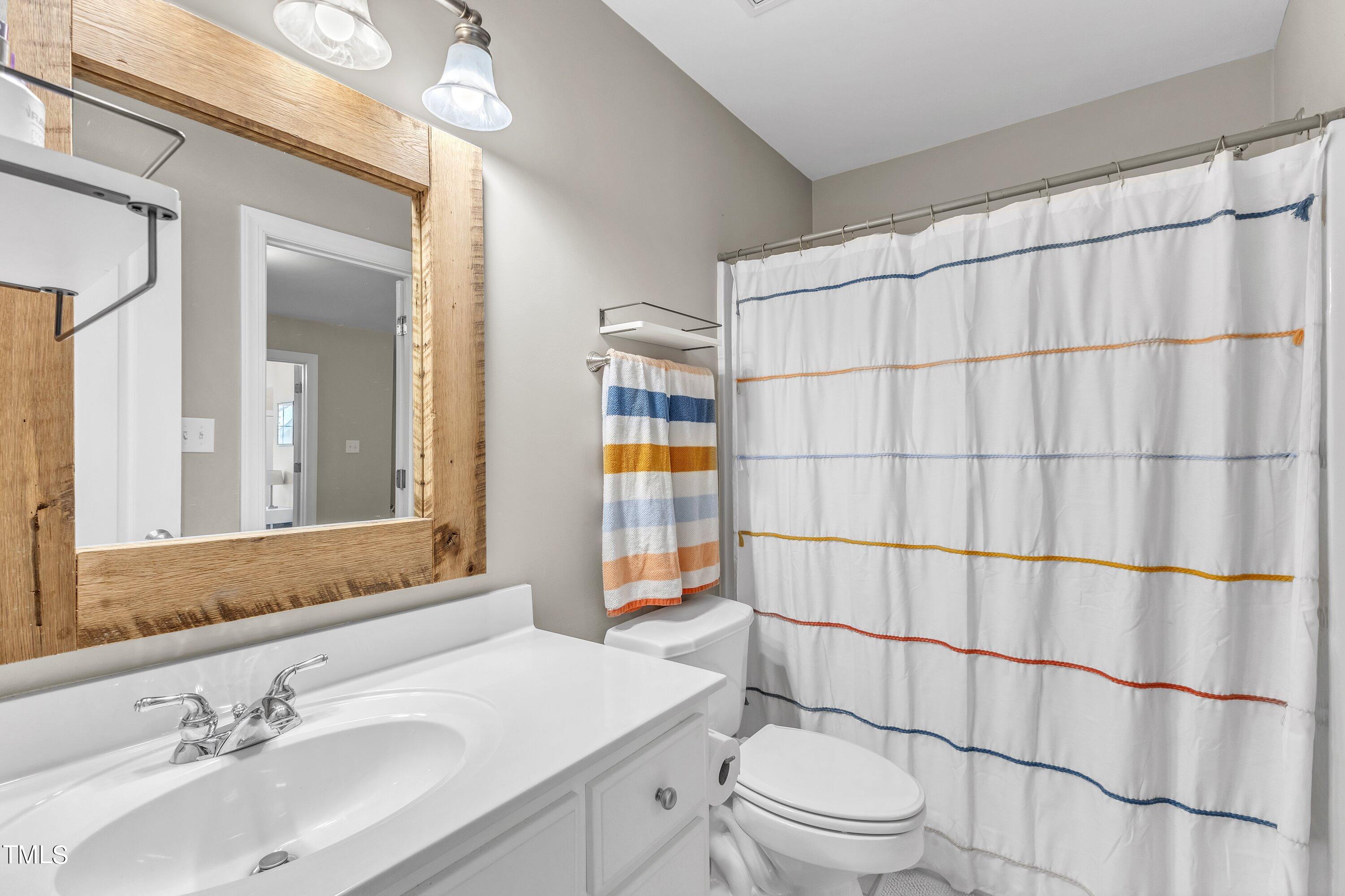6323 Cedar Waters Drive Raleigh, NC 27607 - Photo 54 of 84 a bathroom with a sink a toilet and shower curtain