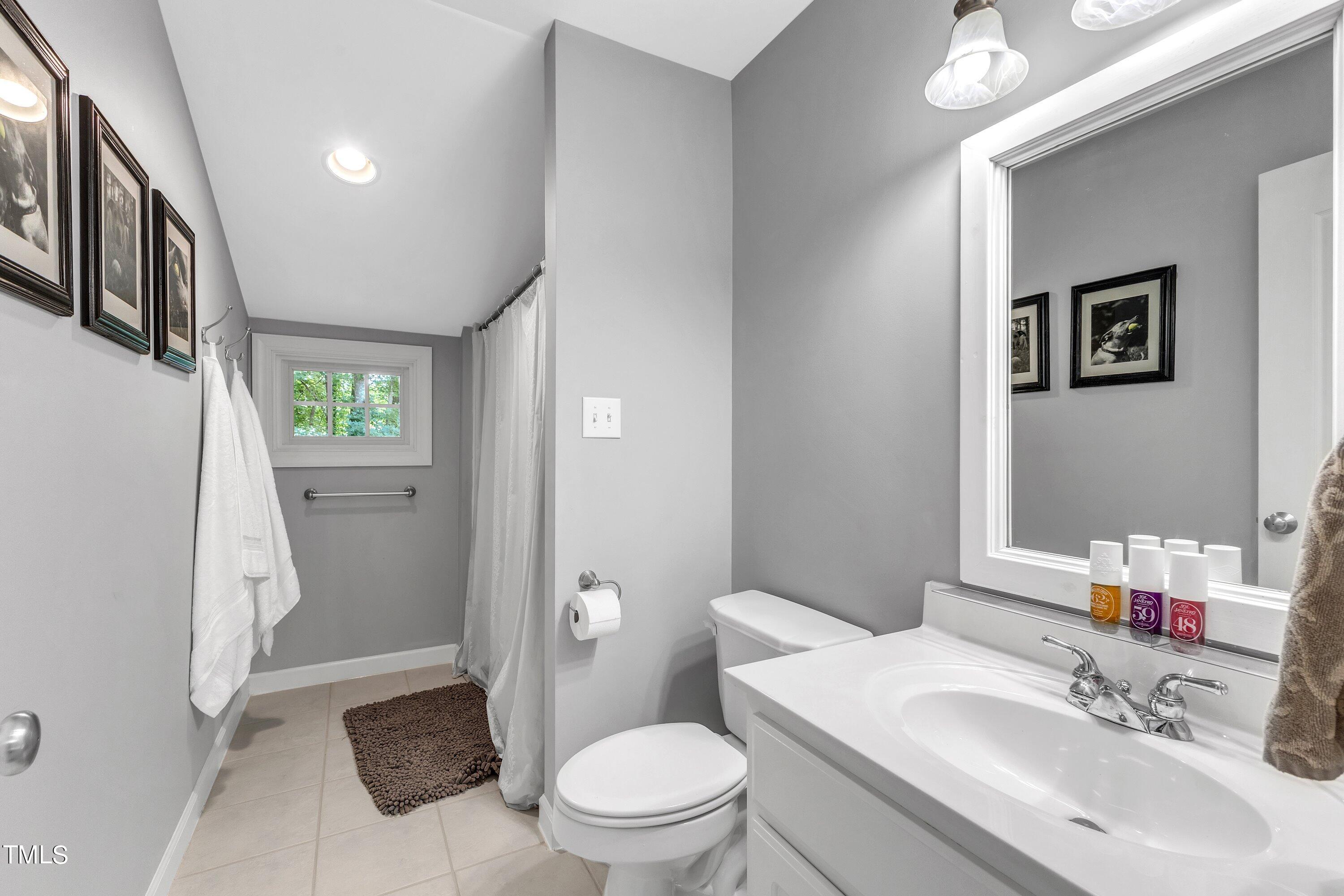 6323 Cedar Waters Drive Raleigh, NC 27607 - Photo 59 of 84 a bathroom with a sink vanity mirror and toilet