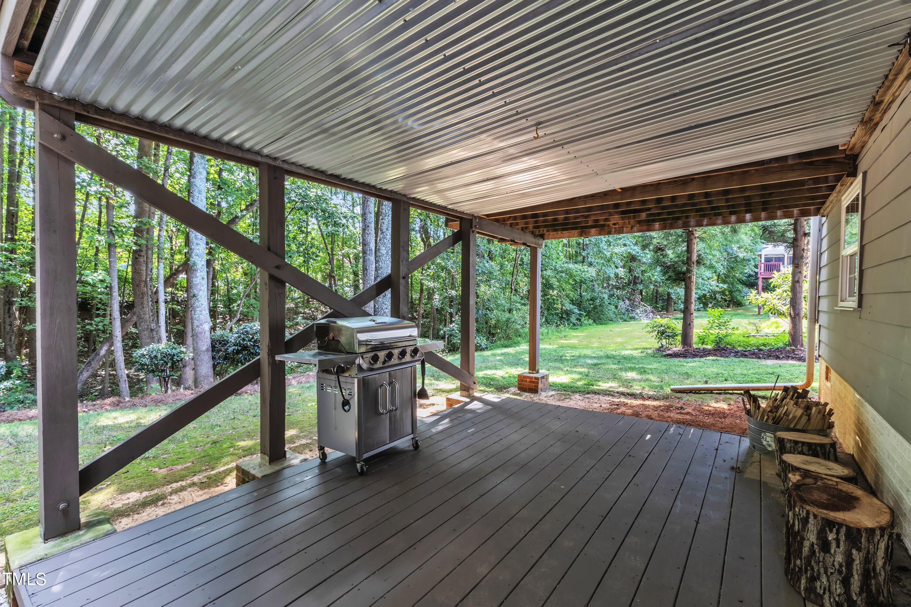 6323 Cedar Waters Drive Raleigh, NC 27607 - Photo 72 of 84 a view of a patio with table and chairs under an umbrella with wooden floor