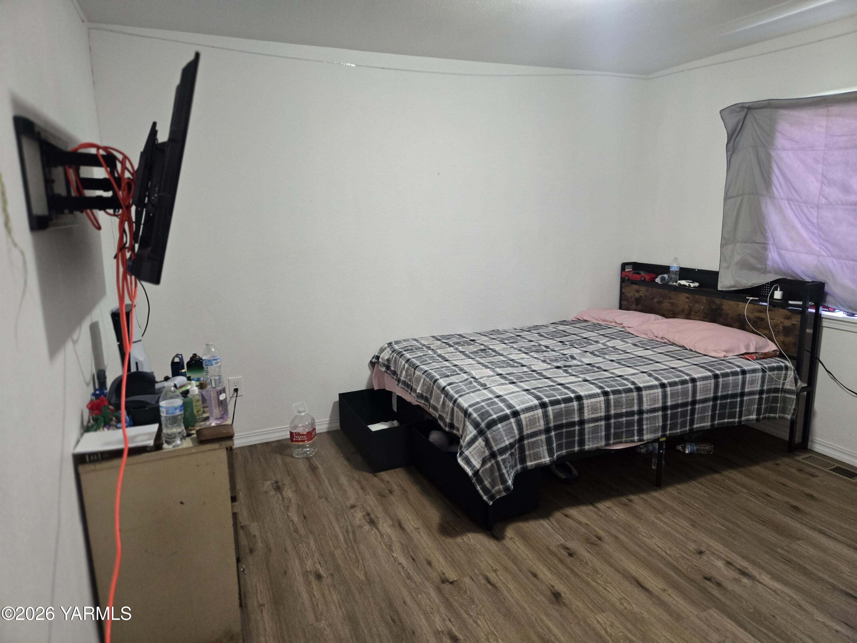 208 North Chestnut Street Toppenish, WA 98948 - Photo 8 of 10 a bedroom with a bed and wooden floor
