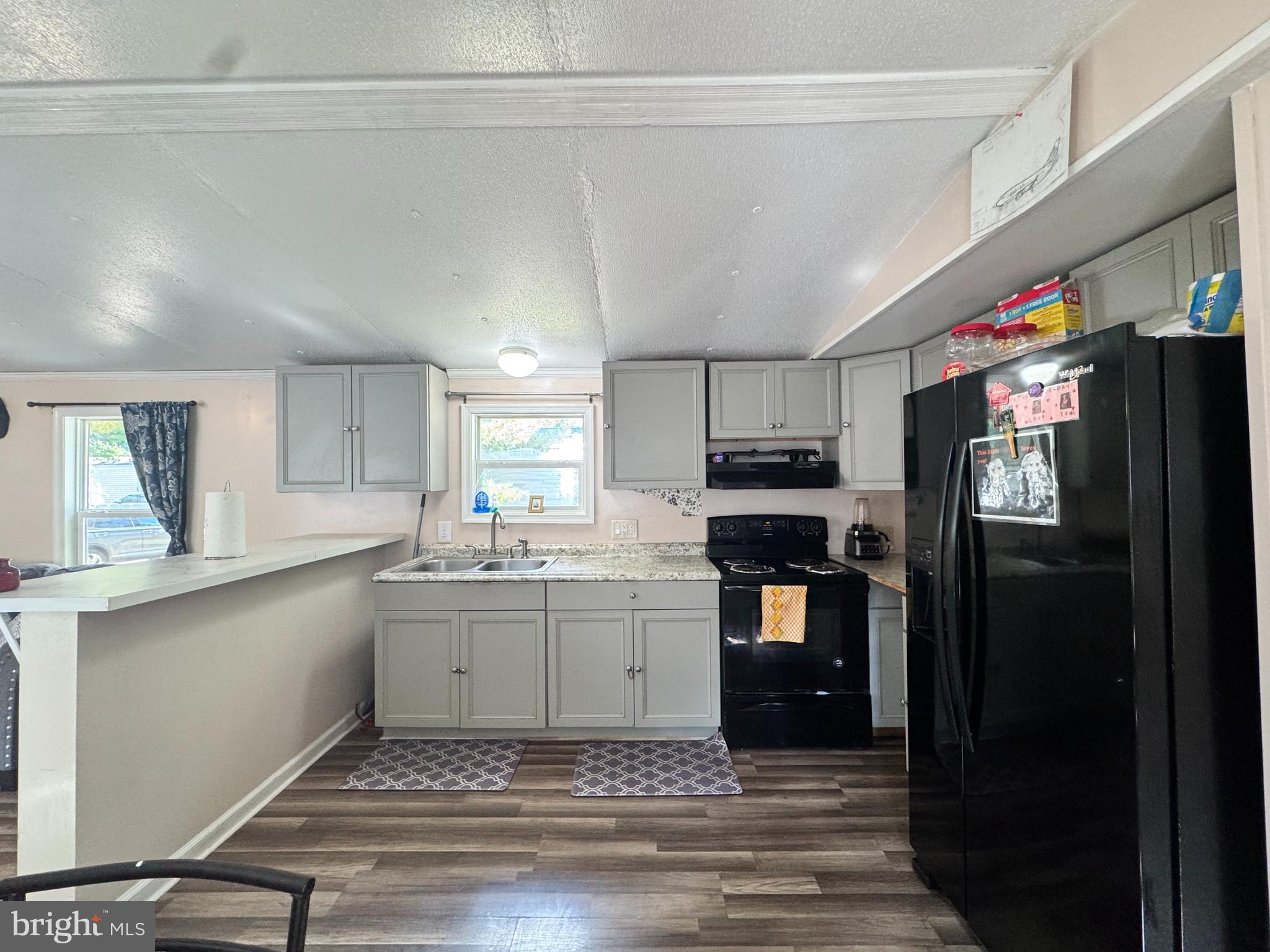 229 Sand Castle Boulevard Fruitland, MD 21826 - Photo 10 of 27 a kitchen with stainless steel appliances kitchen island granite countertop a refrigerator and a stove top oven