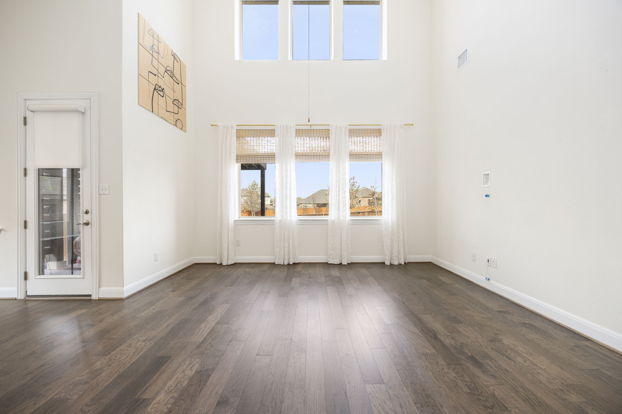 1098 Cherrystone Loop Buda, TX 78610 - Photo 14 of 37 an empty room with wooden floor and windows