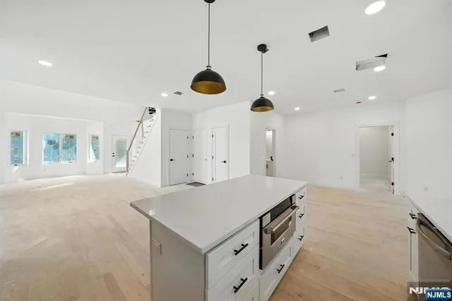 a kitchen with stainless steel appliances granite countertop a sink a stove and a wooden floors