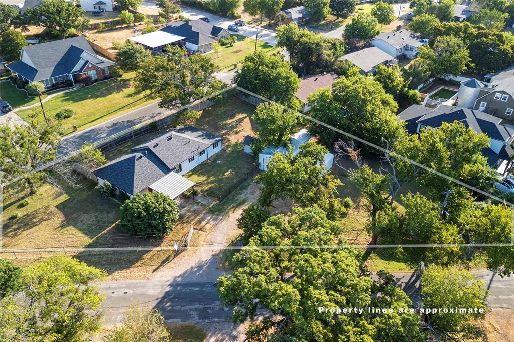 310 North Road Kennedale, TX 76060 - Photo 22 of 23 Single-story residence with a dark shingle roof, accompanied by a detached structure