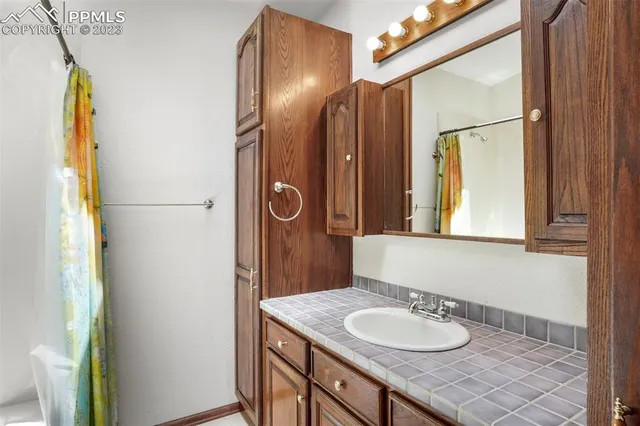 a bathroom with a granite countertop sink and a mirror