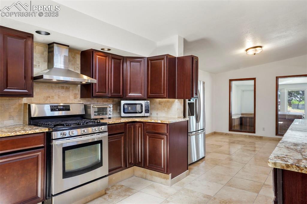 24725 Speer Road Calhan, CO 80808 - Photo 3 of 48 a kitchen with granite countertop wooden cabinets and stainless steel appliances