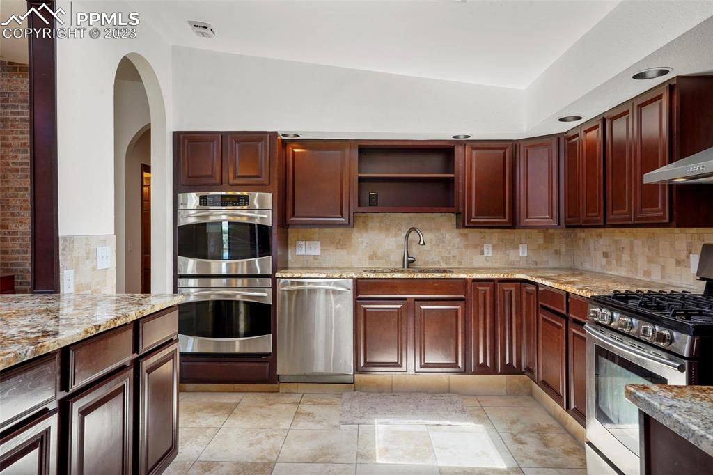 24725 Speer Road Calhan, CO 80808 - Photo 4 of 48 a kitchen with stainless steel appliances granite countertop a stove top oven a sink dishwasher and microwave oven