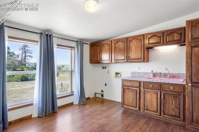 a kitchen with stainless steel appliances granite countertop a stove a sink and a refrigerator with wooden floor