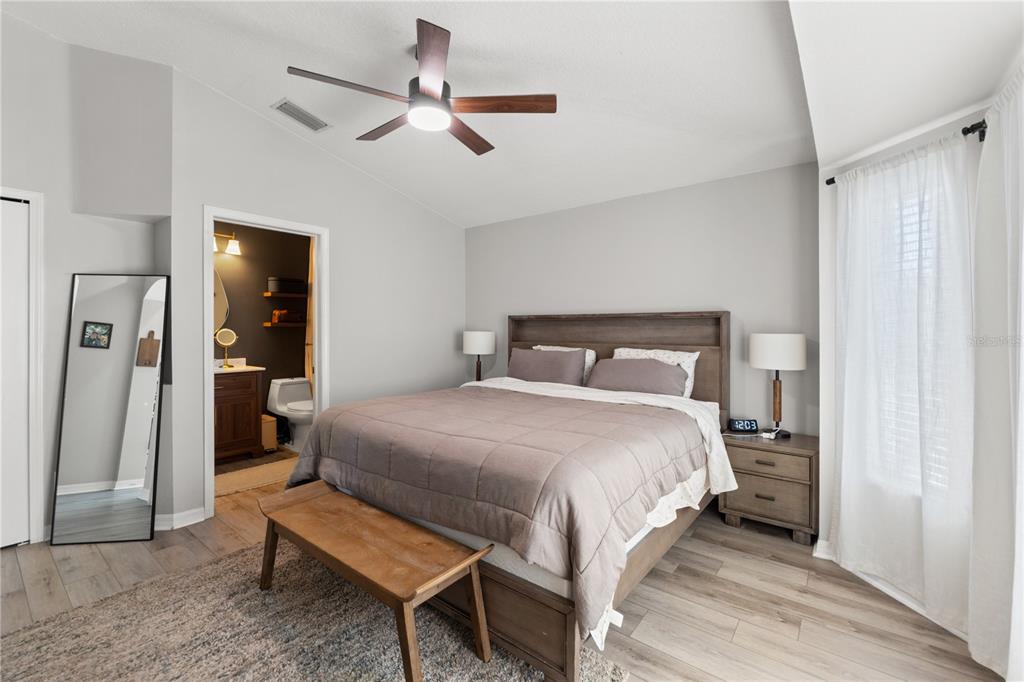 12310 Boot Spur Way Spring Hill, FL 34610 - Photo 13 of 36 a bedroom with a bed a ceiling fan and a rug
