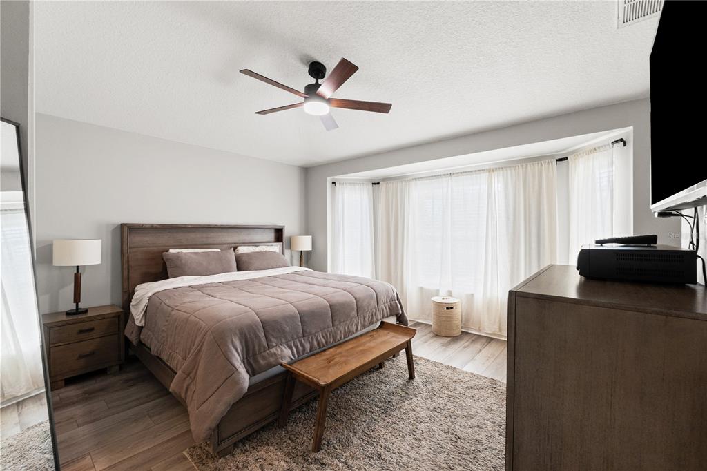 12310 Boot Spur Way Spring Hill, FL 34610 - Photo 16 of 36 a bedroom with a bed and a chandelier
