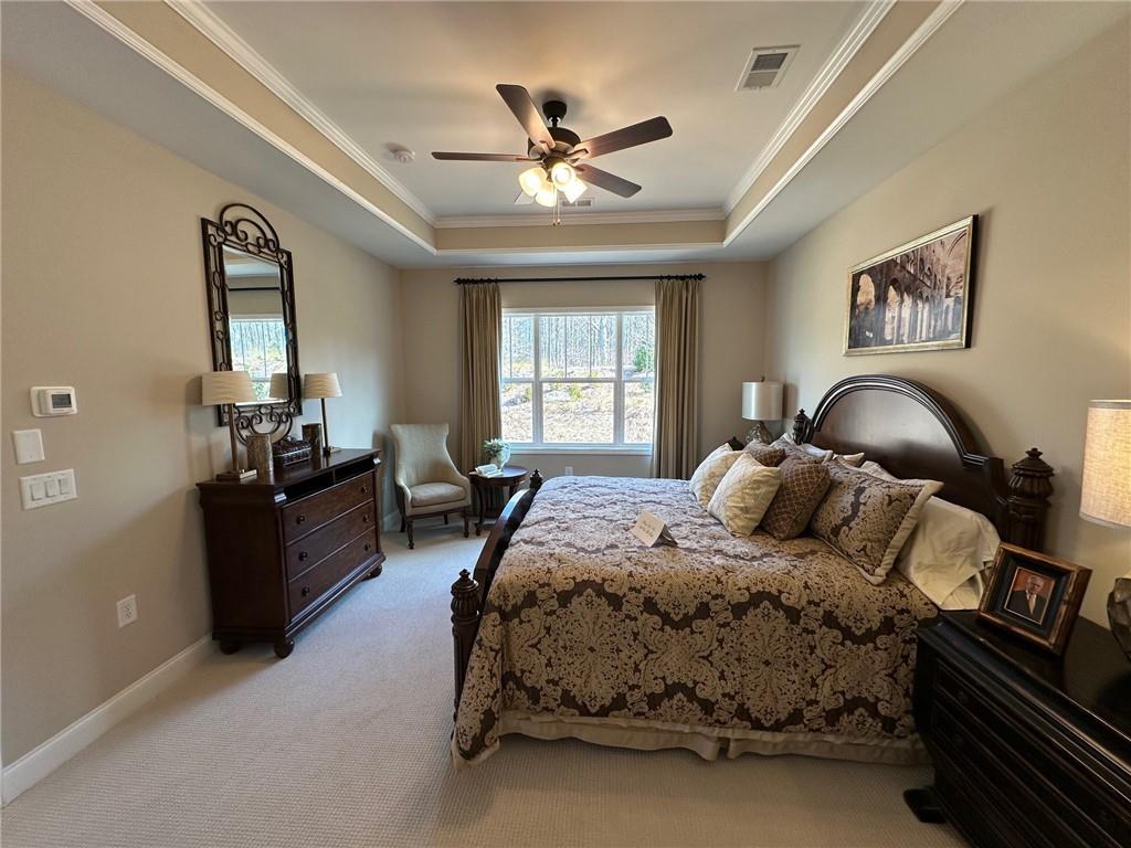 1001 Calypso Way, Unit 1001 Cumming, GA 30040 - Photo 11 of 27 a bedroom with a large bed and a chandelier
