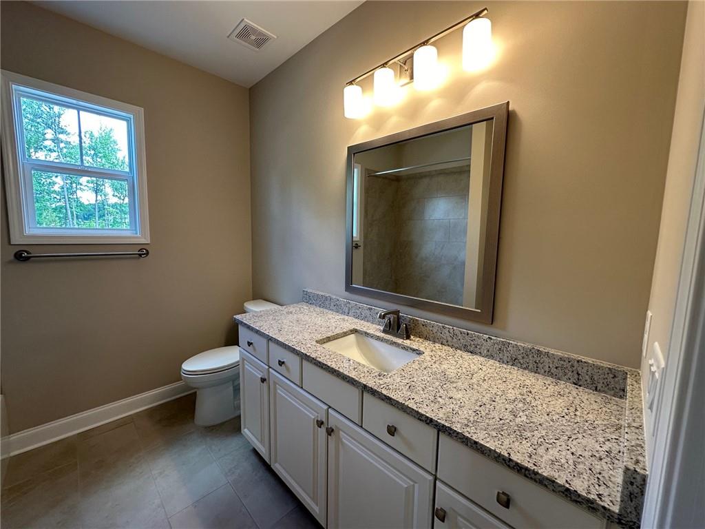 1001 Calypso Way, Unit 1001 Cumming, GA 30040 - Photo 18 of 27 a bathroom with a granite countertop sink toilet and mirror