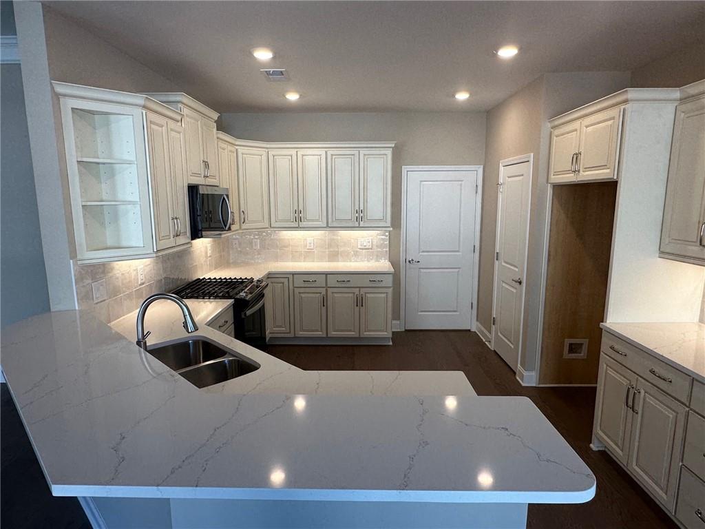 1001 Calypso Way, Unit 1001 Cumming, GA 30040 - Photo 3 of 27 a large kitchen with stainless steel appliances a refrigerator and a stove top oven